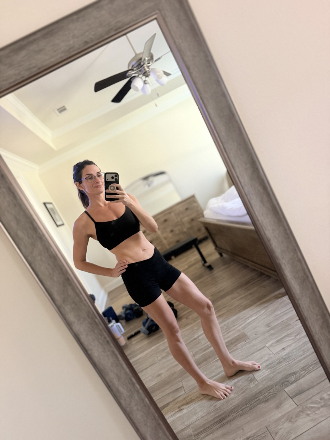 Ashley taking a mirror photo in her home workout space